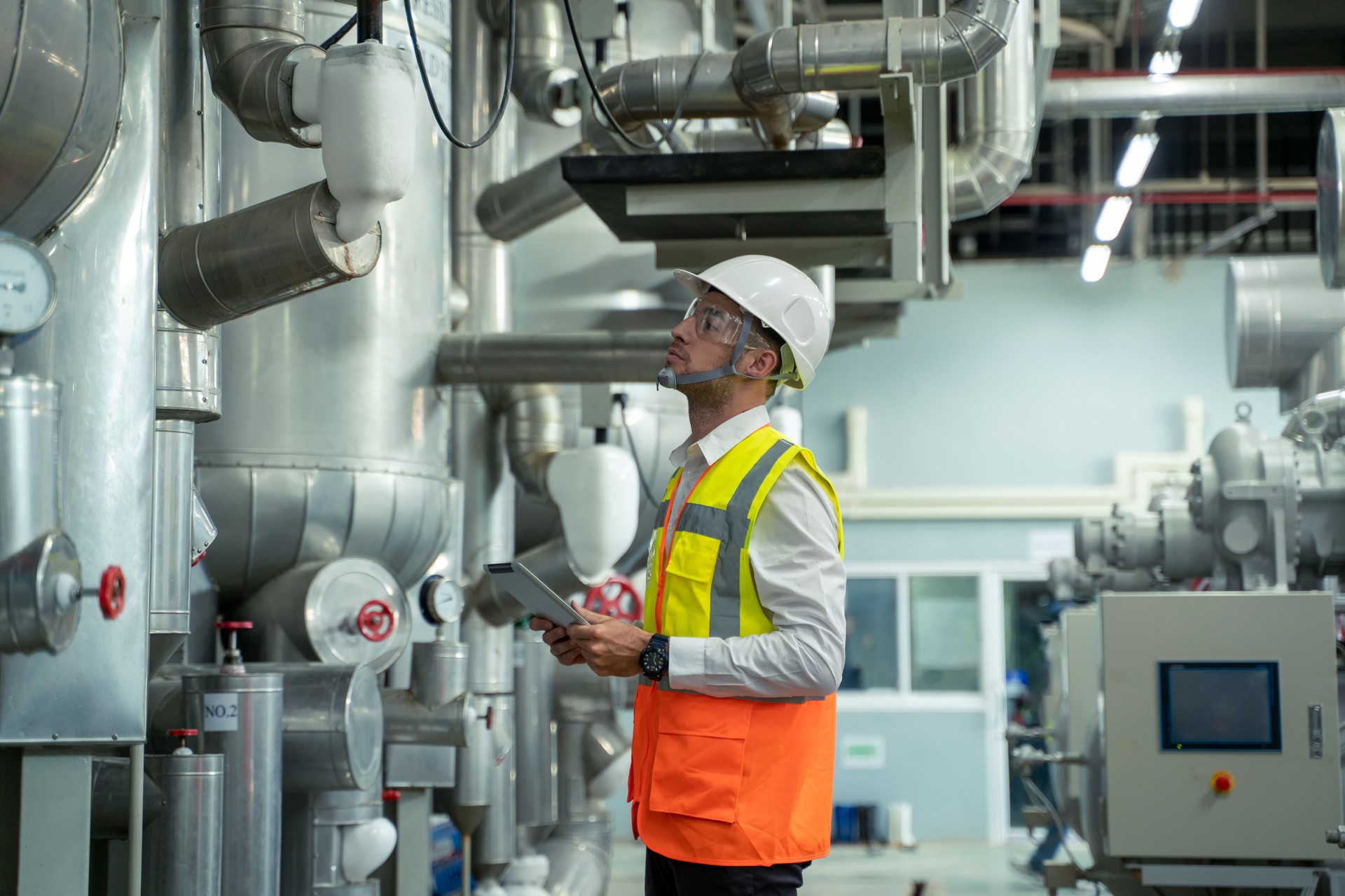 Engineer checking and maintenance technical data of system equipment condenser Water pump and piping air compressor system.