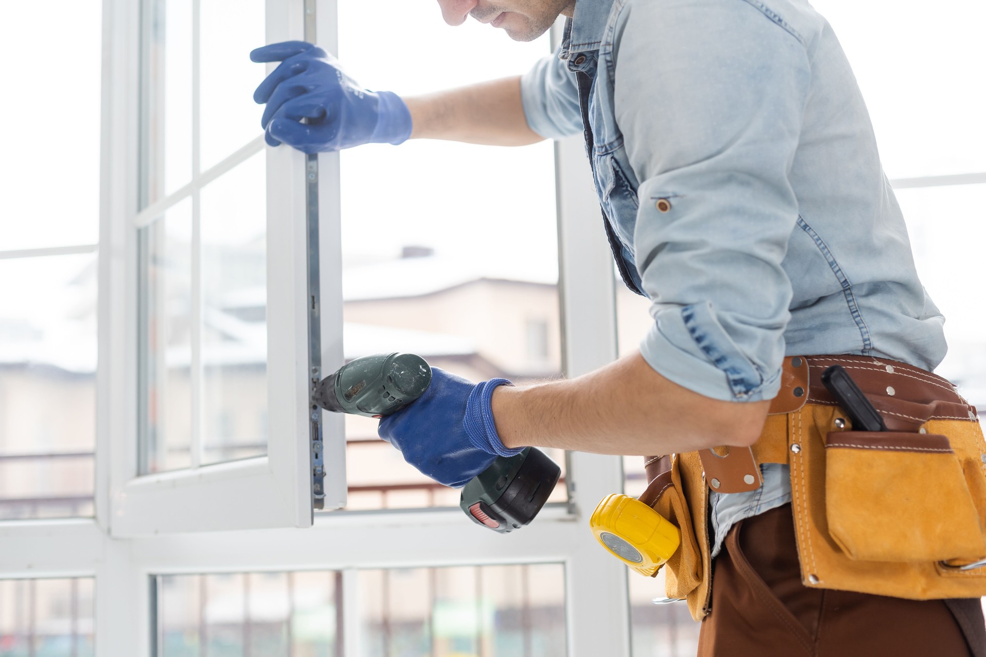 Construction worker installing window in house. Handyman fixing the window with screwdriver