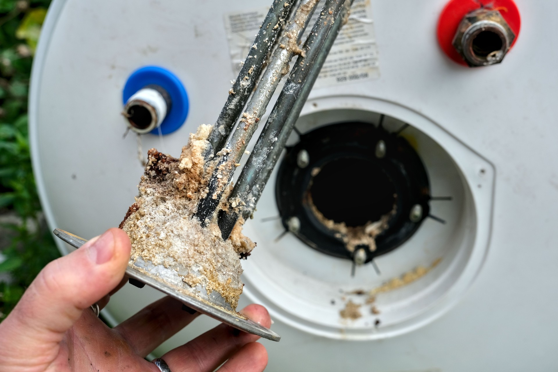 Electric water heater heating element, worn and covered with limescale.